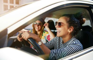 laughing-young-girlfriends-traveling-in-a-car